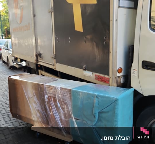 משאית הובלה עם חבילה עטופה בניילון על עגלה